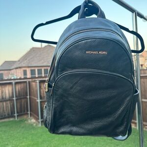 Michael Kors soft grain, black leather backpack with gold hardware.